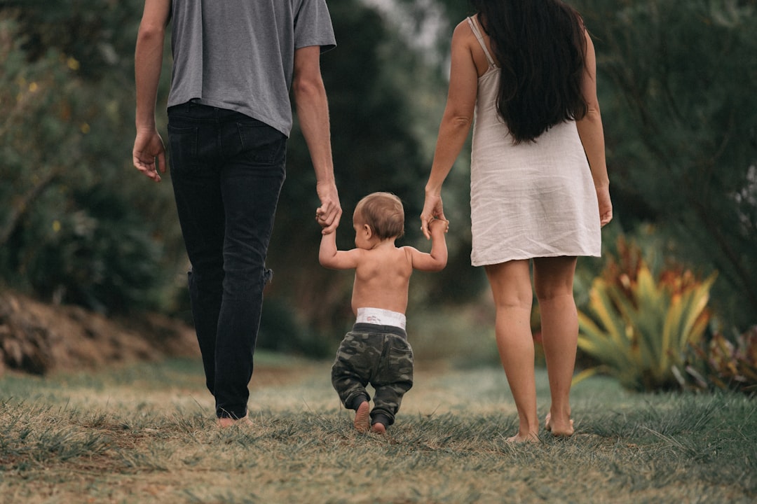 couple-walking-barefoot-with-a-child-at-the-garden-m0m-fr2iedk